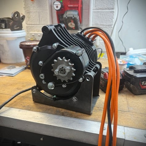 Motor with gears and orange cables on a workbench